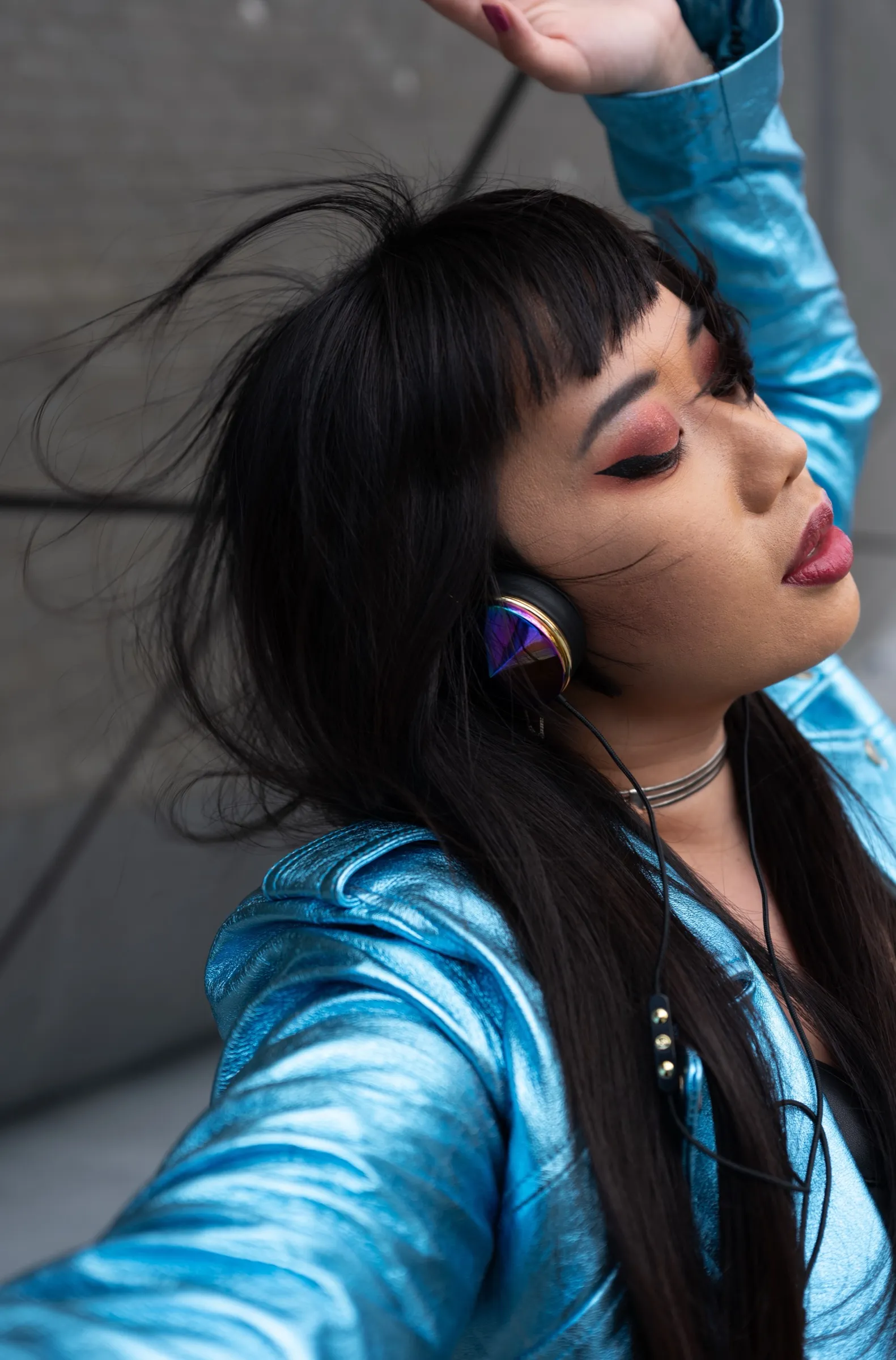 Xiang Yu Yeung in a holographic blue jacket and iridescent headphones