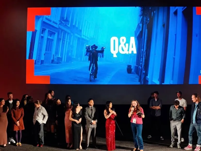 The cast and crew lined up on stage beneath the cinema screen during the premiere Q&A